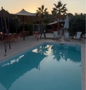 Piscine et terrasse d'AZÙRA by Terre et Mer à Labège au coucher du soleil, transats, parasols et palmiers